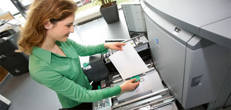 Productive woman printing out pages in a sunny and modern Sydney office